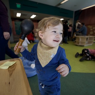 Joyful Toddler Playing with Toy Mallet Indoors