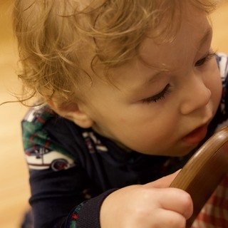 Toddler with Blonde Curls Focused on Wooden Spoon