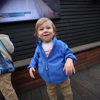 Joyful Toddler at Indoor Venue with Digital Display