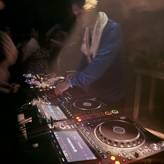 DJ Performing with Professional CDJ Setup at Night