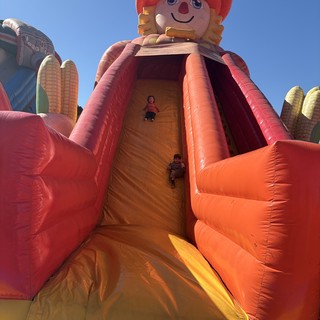 Children Sliding Down Giant Inflatable Harvest Doll