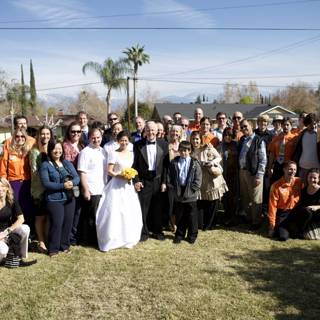 Wedding Party Poses for Photo in Front of Beautiful Home