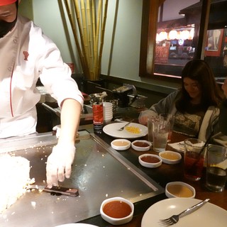 Hibachi Chef Cooking for Diners at Teppanyaki Restaurant