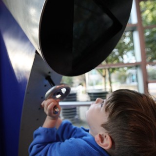 Child Exploring Interactive Exhibit at Science Center