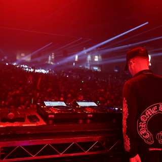 DJ Commands Massive Crowd Under Red Festival Lights