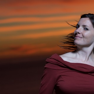 Woman in Red Against a Fiery Sunset Sky