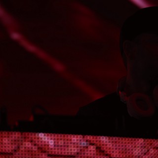 Silhouetted DJ Performing Under Crimson Stage Lights