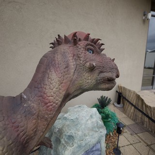 Whimsical Dinosaur Statue at Modern Building Entrance