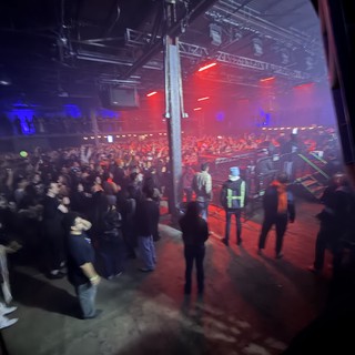 Red-Lit Industrial Warehouse Concert with Crowd and Security