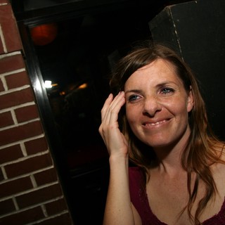 Candid Portrait of Smiling Woman in Dimly Lit Bar