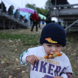 Young Lakers Fan Enjoying Skewered Treats at Festival