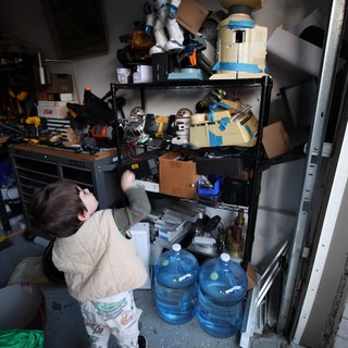 Young Child Exploring Workshop Storage Shelves