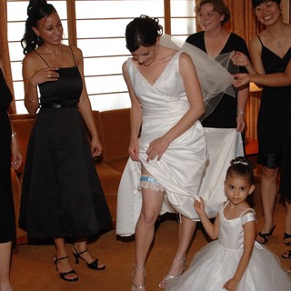 Bride Shows Off Wedding Garter with Bridesmaids