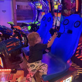 Child Playing Virtual Reality Motorcycle Racing Game in Arcade