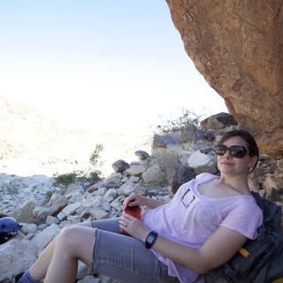 Desert Hiker Resting in the Shade of a Boulder