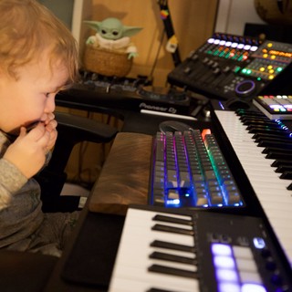 Young Child Explores Music Production Setup at Home