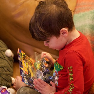Boy Opening Action Figure Toy on Christmas Morning