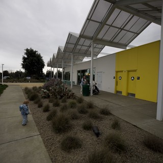 Child Explores Modern Community Center Courtyard