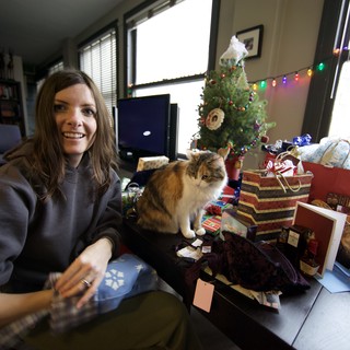 Holiday Joy: Woman and Cat Amid Christmas Gifts