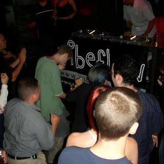 Nightclub Crowd Gathers Around DJ