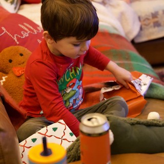 Child Opening Christmas Presents on Cozy Morning