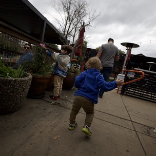 Children Playing on Restaurant Patio Under Cloudy Skies