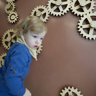Toddler Exploring Interactive Gear Wall Display