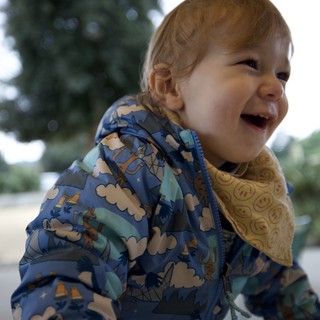 Joyful Toddler in Dinosaur Print Winter Jacket