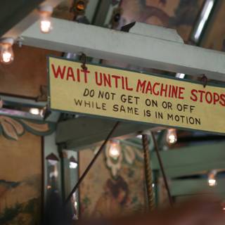 Wait Until Machine Stops Sign in Industrial Cafeteria