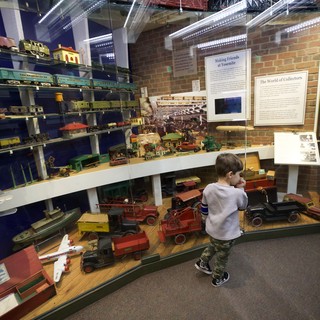 Young Boy Exploring Vintage Toy Museum Collection