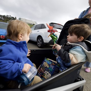 Two Young Children Sharing Moment in Parking Lot Wagon