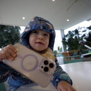 Toddler with Phone at Outdoor Dining Venue