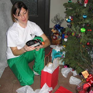 Woman Opening Christmas Gifts by Decorated Tree