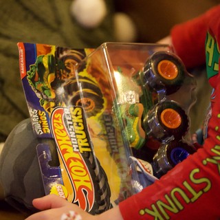 Child Opening Monster Trucks Toy on Christmas Eve