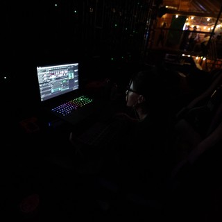 DJ Operator Controls Lights in Dark Festival Booth