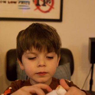 Young Boy Opening Gift on Christmas Evening