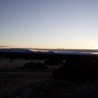 Sunset Over Mountain Silhouettes in Desert Landscape