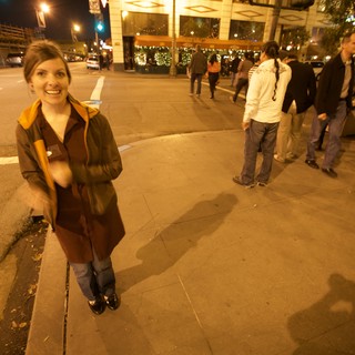 Smiling Woman on Bustling City Street at Night