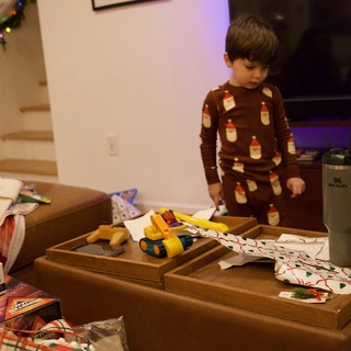 Child Opening Christmas Presents in Cozy Living Room