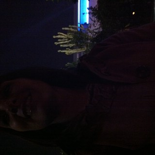 Woman Gazing Upward by Illuminated Pool at Night