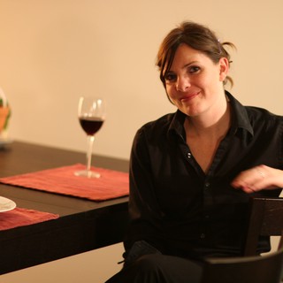 Woman Relaxing at Dinner Table with Red Wine