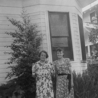 Two Women Posing in Front of a Rural Home