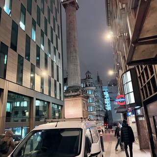 Monument Column Towers Over Modern London Street at Night