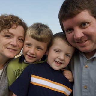 Happy Family of Four Poses Together Outdoors