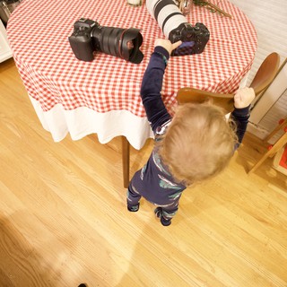 Young Child Reaching for Professional Camera Equipment