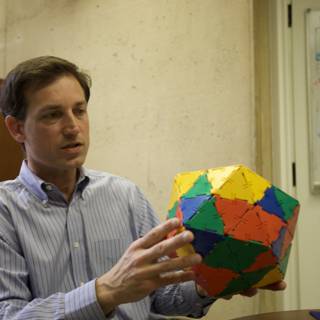 Colorful Sphere in the Hands of a Man