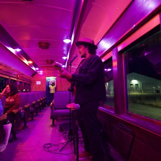 Live Music Performance in Vintage Purple-Lit Train Car