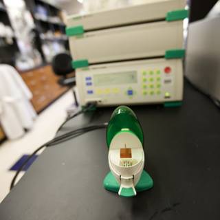 Small Green and White Device on Laboratory Table