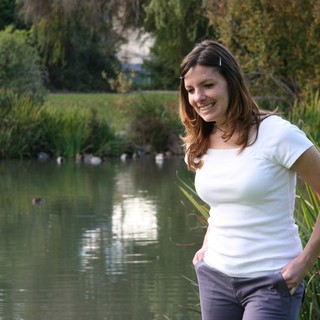 Smiling Woman by a Tranquil Park Pond