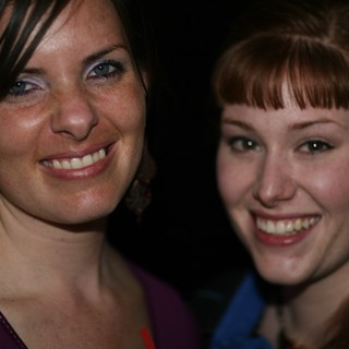 Two Smiling Women at a Nighttime Social Event